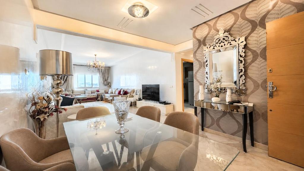 a dining room with a glass table and a mirror at Central luxury apart Mohammedia in Mohammedia