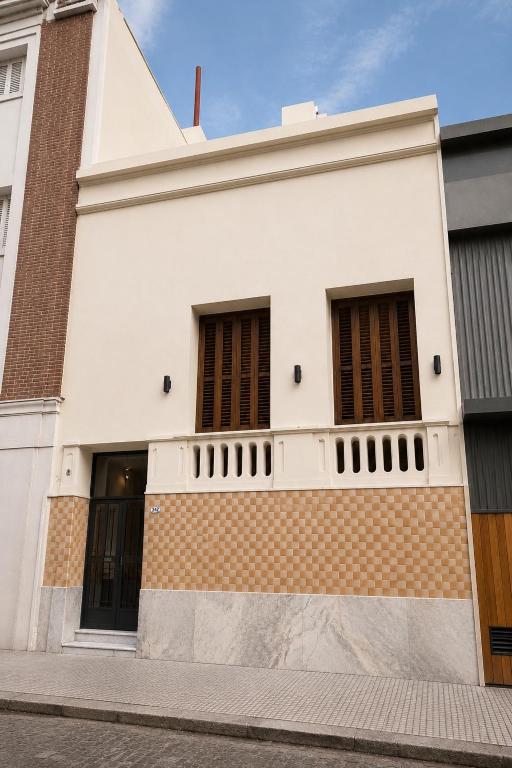 a white building with windows and a brick wall at Hotel Histórico San Telmo in Buenos Aires
