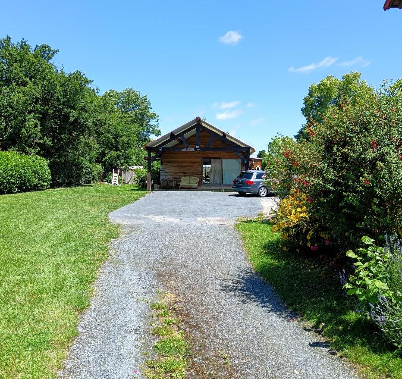 a gravel driveway leading to a log cabin at L'annexe in Gouy