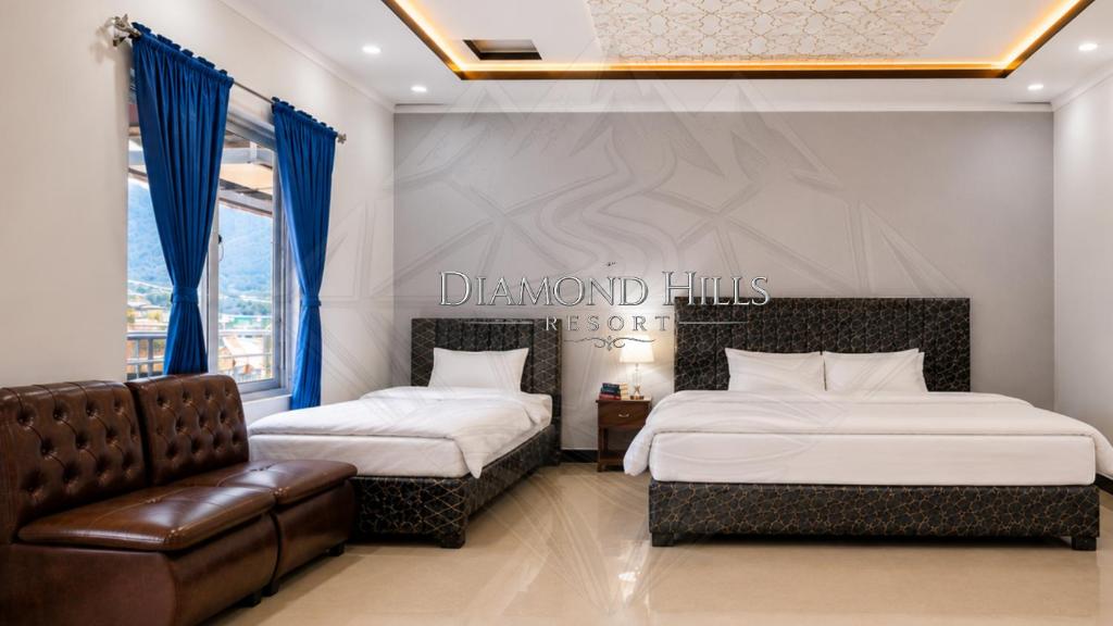 a hotel room with two beds and a chair at Diamond Hills Resort in Battakundi