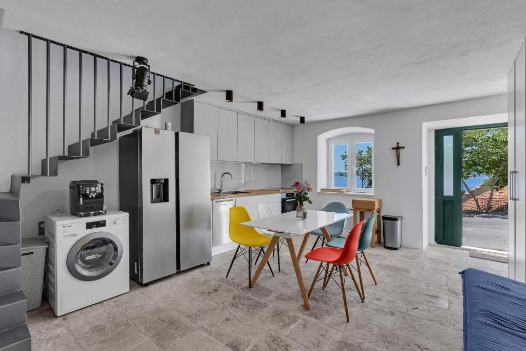 a kitchen with a table and chairs and a staircase at Holiday Home Pelegrin in Brela