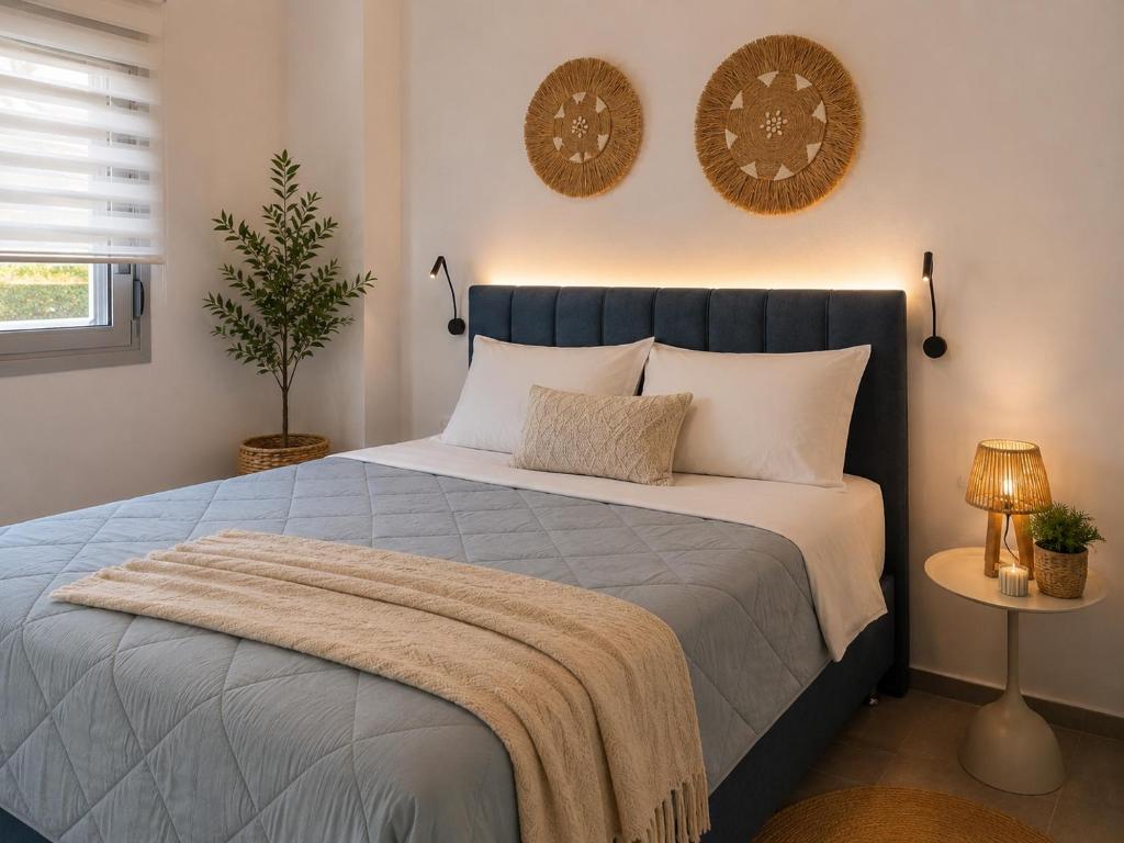 a bedroom with a large bed with a blanket on it at Celivine Seaside Residence in Faliraki