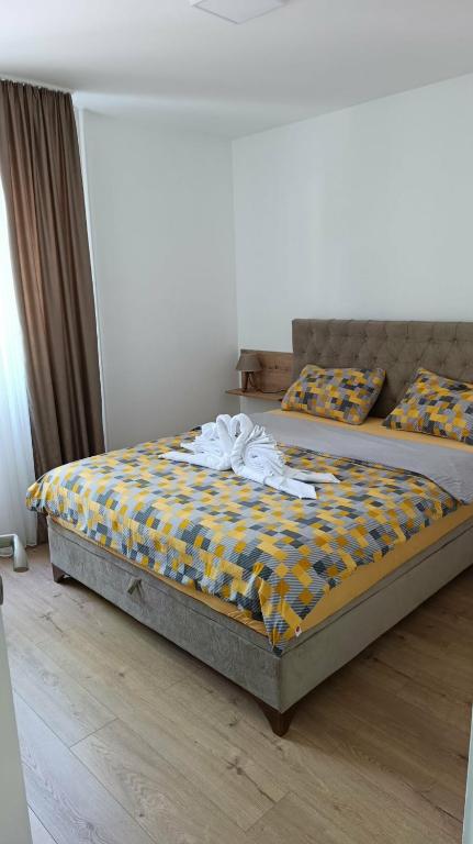 a bedroom with a bed with a yellow and blue comforter at Apartman Pavlov 023 in Zrenjanin