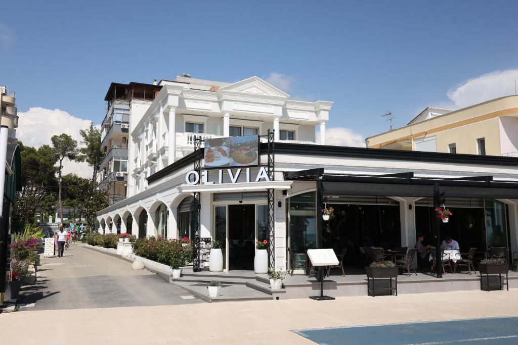 a building with a sign on the front of it at Olivia Hotel in Durrës