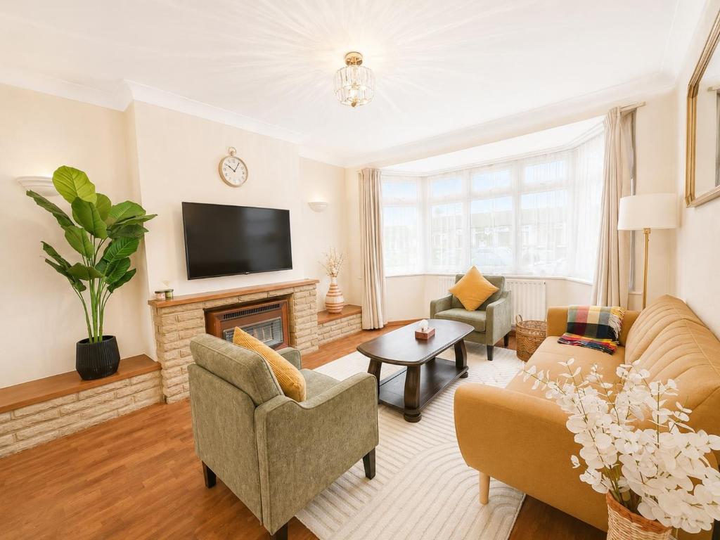 a living room with a couch and a fireplace at Ashwood Stays in Surbiton