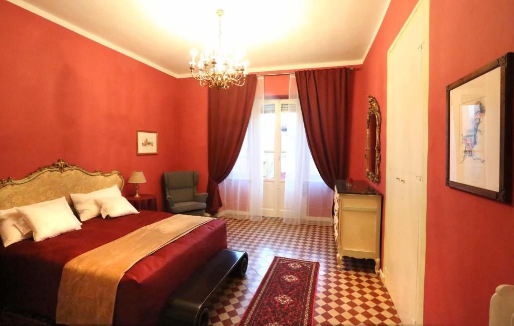 um quarto vermelho com uma cama e um lustre em Casa del Fotografo em Alba