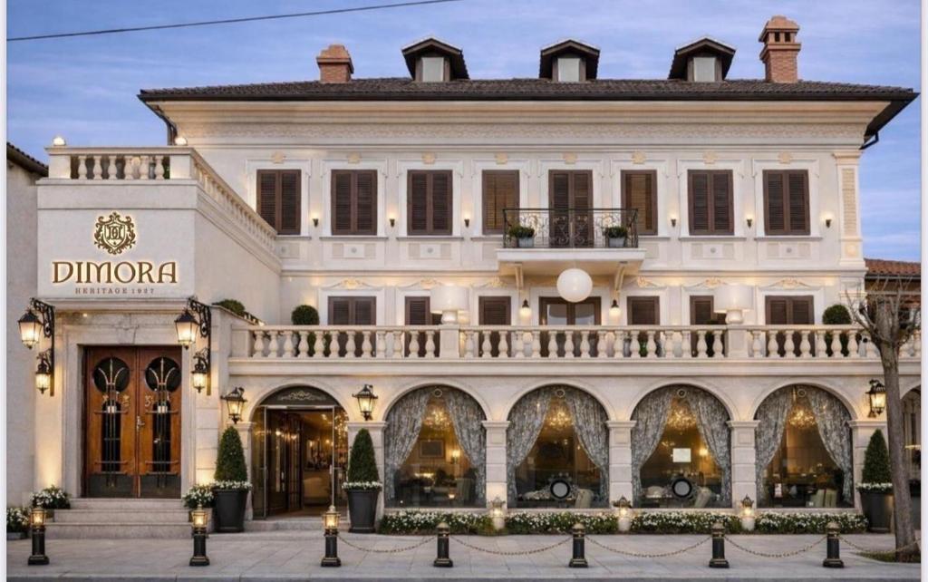 a large white building with a store at Hotel Dimora 1927 in Tirana