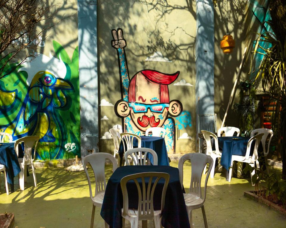 a table and chairs with a painting on the wall at Trem Chic in Belo Horizonte