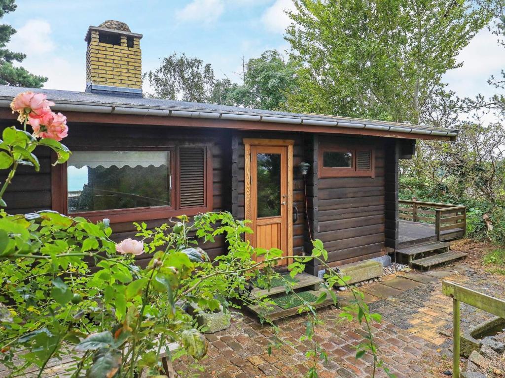 a cabin with a wooden door in a garden at 6 person holiday home in Rudkøbing in Spodsbjerg