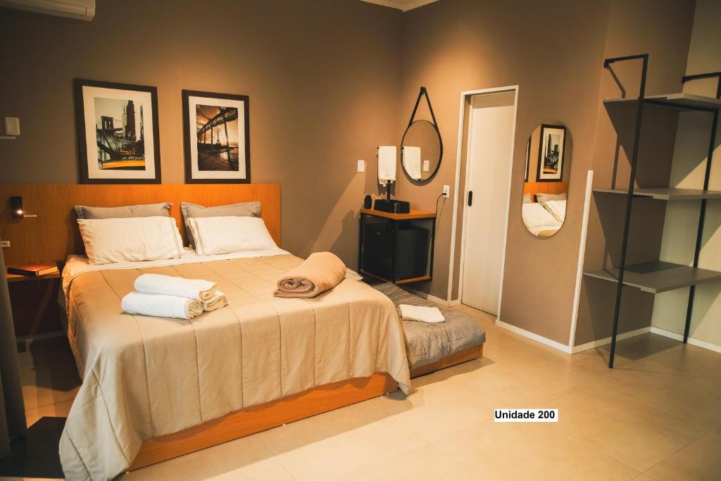 a bedroom with a bed with towels on it at Rio Branco 688 - Hospedagem Premium in Santa Maria