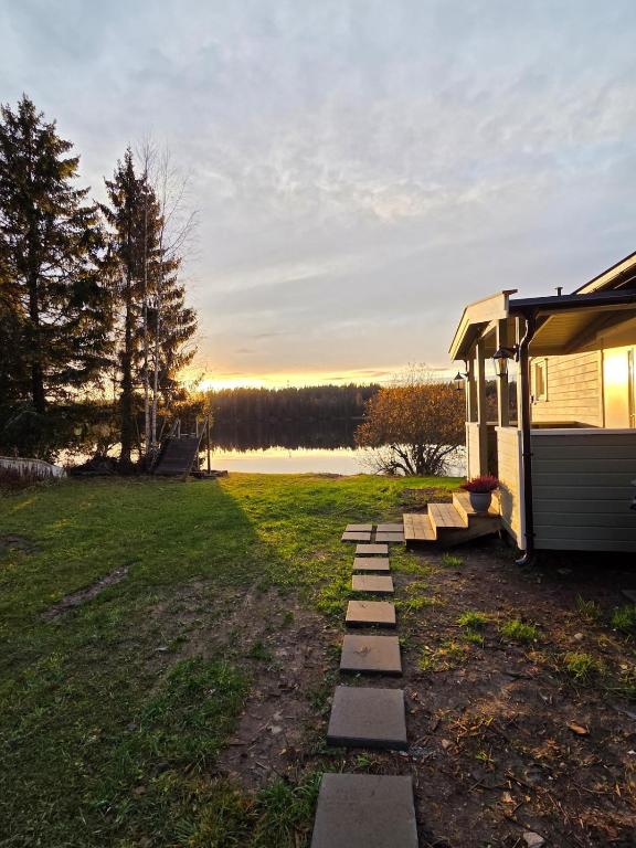 a house with a pathway next to a lake at Unique Villa by a beautiful lake in Omberg