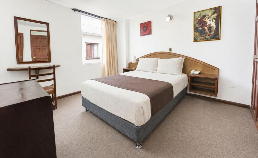 a hotel room with a bed and a mirror at Hotel Los Angeles in Arequipa
