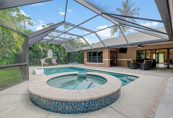 a swimming pool in a house with a glass roof at Elegant, 4 BDR house with a pool and BBQ in Wellington