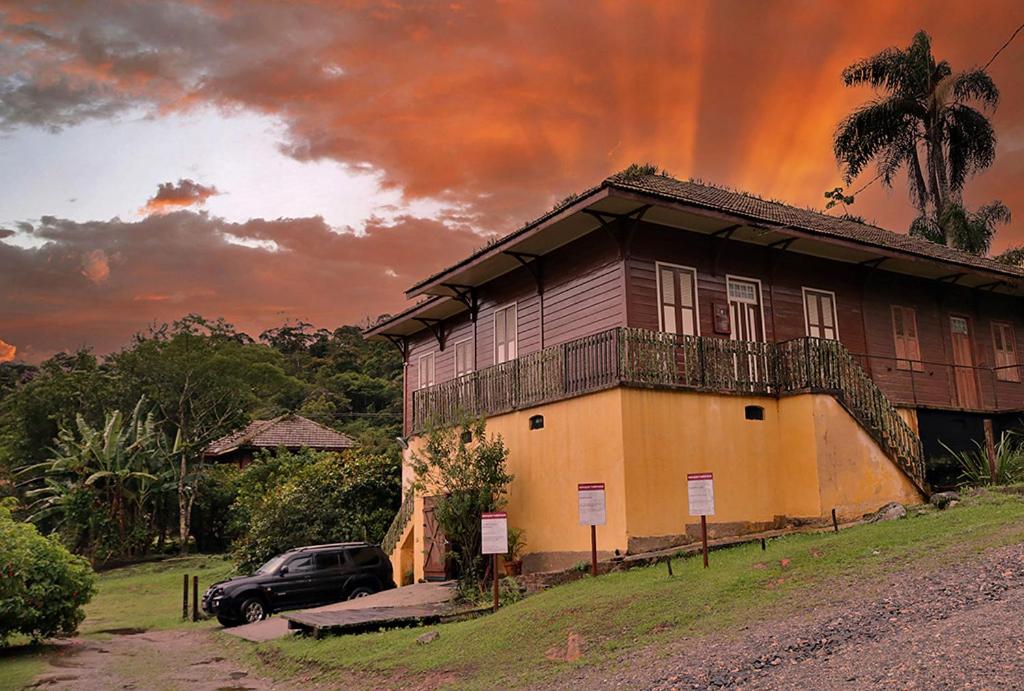 a house with a car parked in front of it at Hospedaria Os Memorialistas - Paranapiacaba in Paranapiacaba