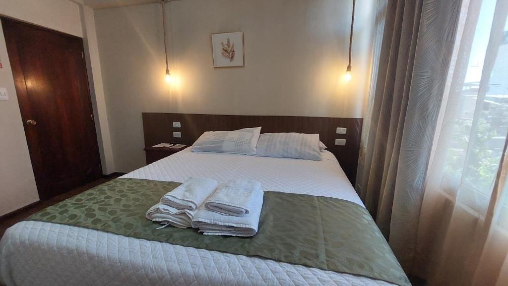 a bedroom with a bed with towels on it at Hotel Islas Galapagos in Puerto Baquerizo Moreno