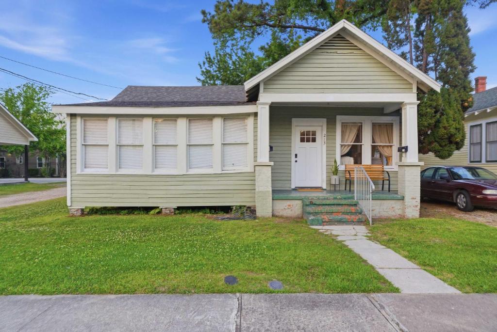 a small green house with a porch at Cozy 1BR Cottage w Kitchen & Laundry in Lafayette