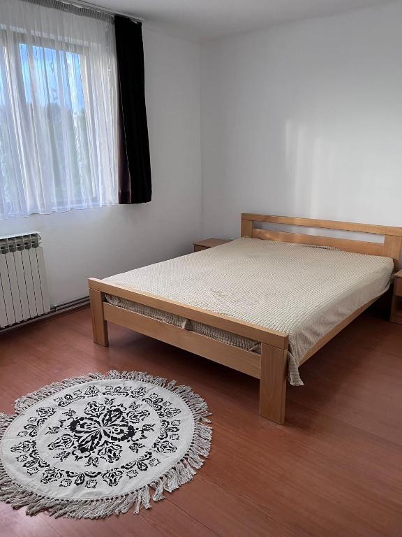 a bedroom with a bed and a rug and a window at Nedzarici sobe in Sarajevo