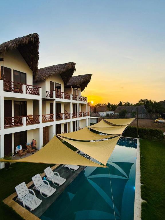 a resort with a swimming pool with chairs and umbrellas at Hali, El Paredón in Sipacate