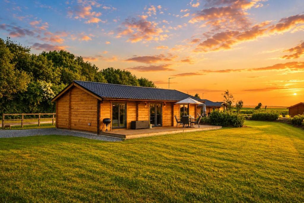 a log cabin in a field with a sunset at 2 Bed in Nafferton oc-b31956 in Nafferton