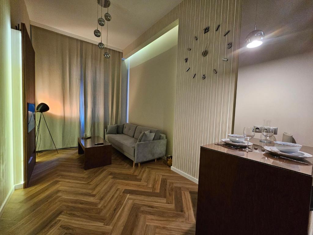 a living room with a couch and a clock on the wall at Vision Luxury Apartment Rynek in Wrocław