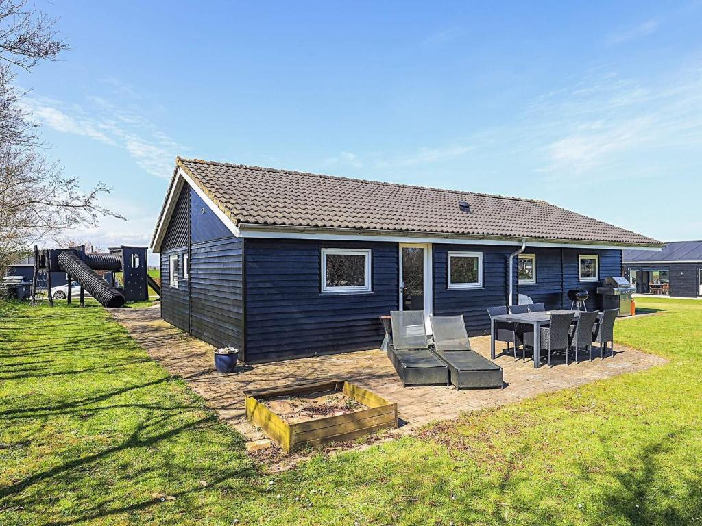 a blue house with a patio and a table and chairs at 4 star holiday home in Vinderup in Vinderup