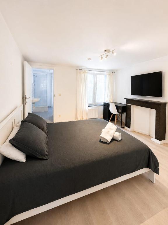 a bedroom with a large black bed and a desk at Maison de Florence in Brussels
