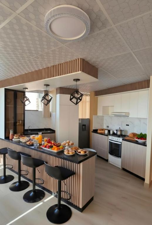 a large kitchen with a breakfast bar with food on it at APART SExTA ESTACIÓN in Juliaca