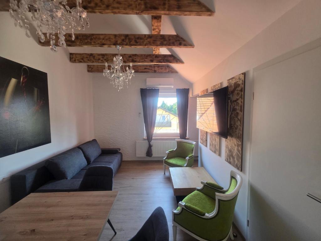 a living room with a couch and a table and chairs at Apartmaji Picasso Design in Veržej