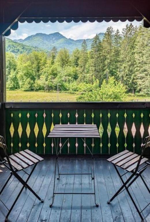 a porch with two chairs and a window with mountains at Riverview Lodge in Bohinj