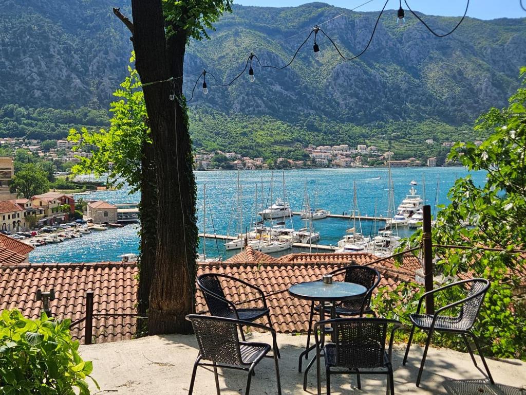 a table and chairs on a patio with a view of a harbor at Stunning Views & Hidden Terraces Above the Old Town in Kotor