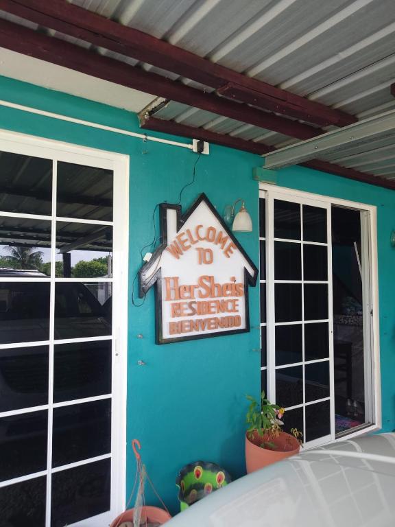 a house sign on the side of a building at Casa HerShei in Orange Walk