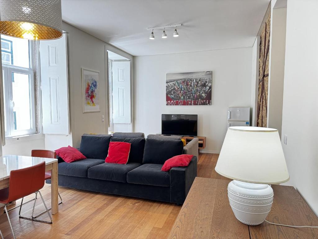 a living room with a black couch and red pillows at Lux Old Town in Lisbon