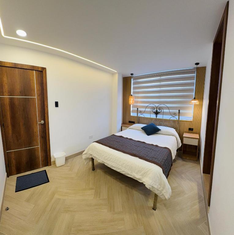 a bedroom with a large bed and a window at Hotel El Altar in Riobamba