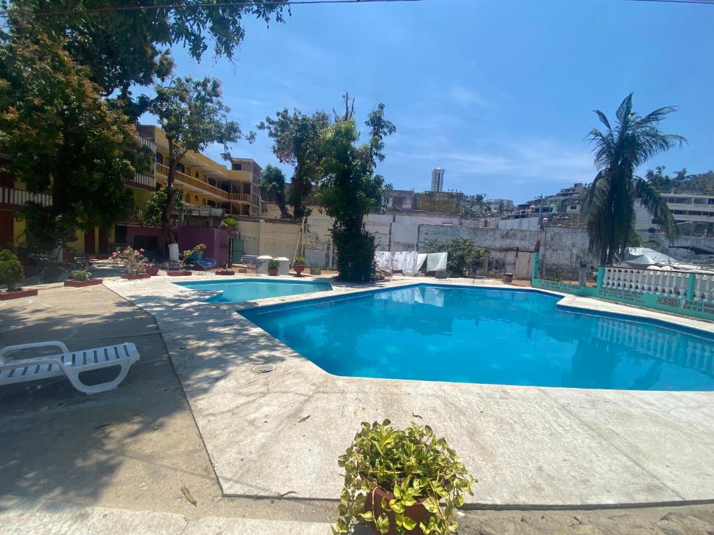 a large swimming pool in a building with a blue at Casa Walton in Acapulco