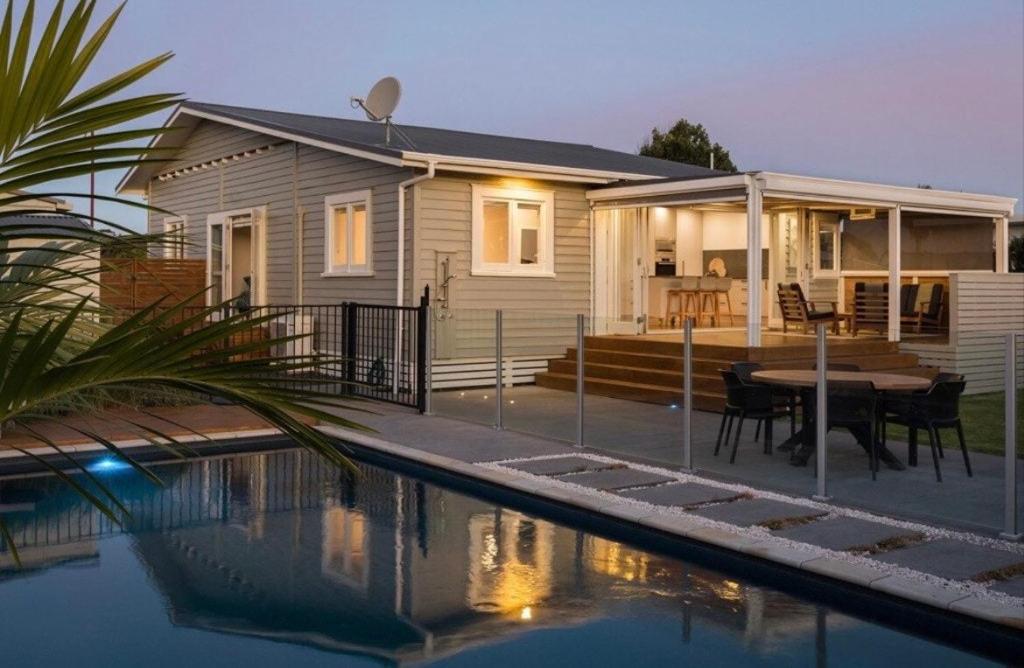 a house with a swimming pool in front of it at Character Villa Oasis - Pool & Beach in Athenree