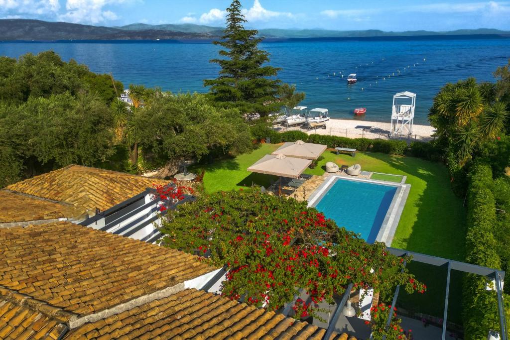 an aerial view of a house with a swimming pool and the ocean at Barbati Beachfront - Pool Villa in Barbati