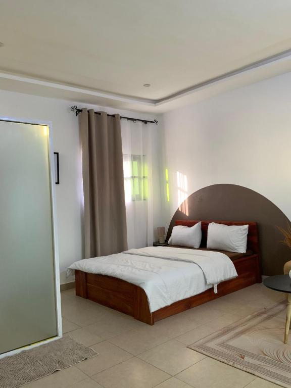 a bedroom with a bed and a large window at Residence Emilienne in Cotonou