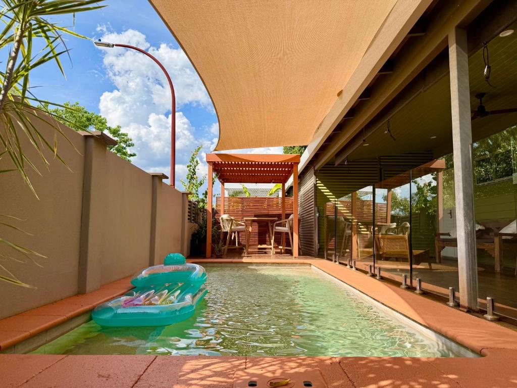 a pool with a inflatable boat in the water at Warm, private, poolside retreat in Cable Beach