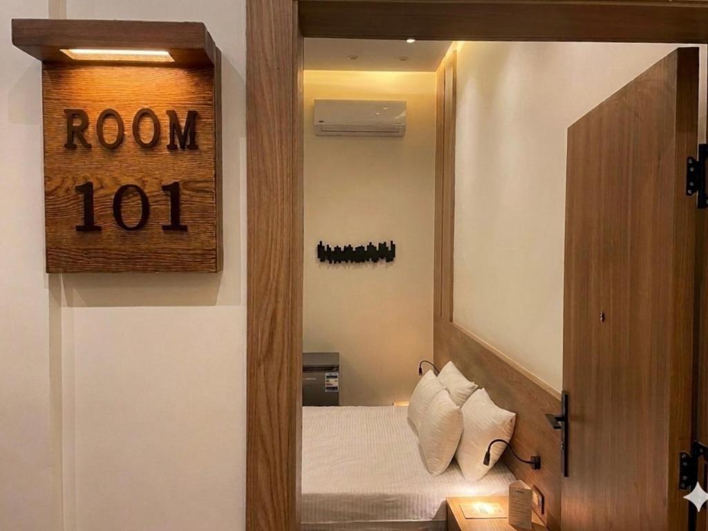a bedroom with a mirror and a room sign at Latina City in Cairo