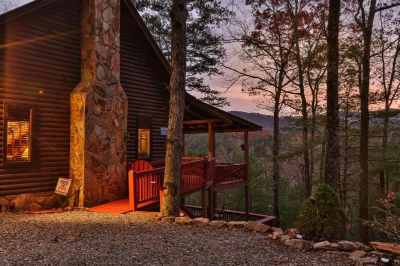 a log cabin with a porch in the woods at Living on the Ledge - Long-Range Mountain Views - Hot Tub and Fire Pit in Blue Ridge