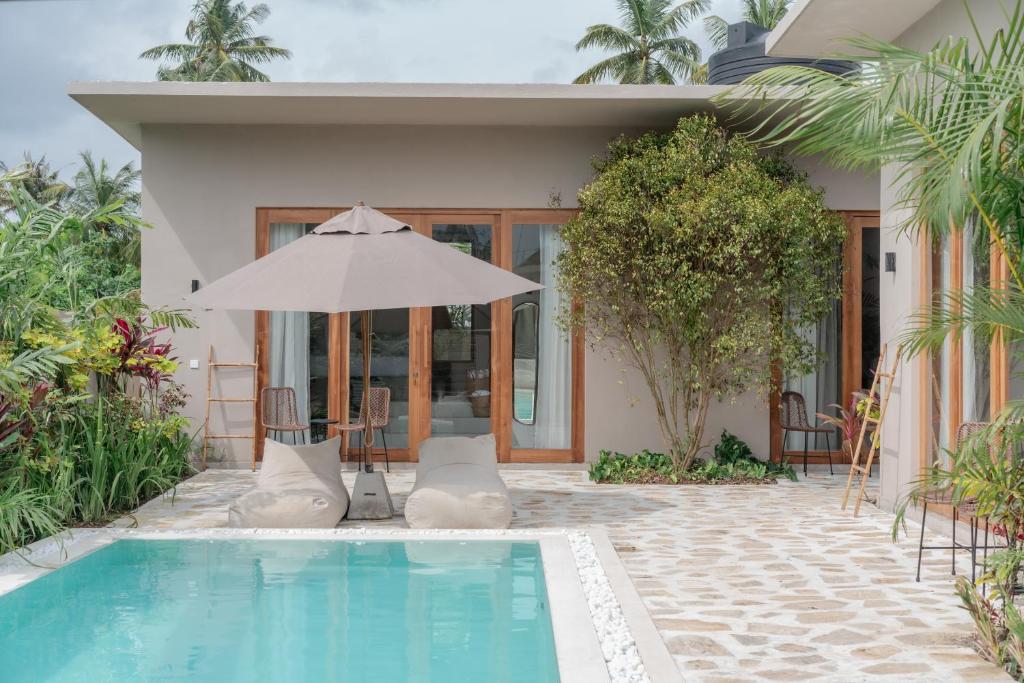 a house with a swimming pool and an umbrella at Tayo Villa in Ahangama
