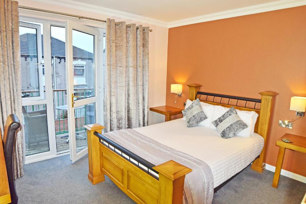 a bedroom with a bed and a large window at Dovedale Hotel and Restaurant in Cleethorpes