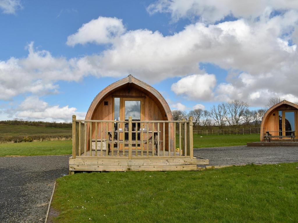 a wooden cabin with a porch in a field at Stainton-Uk1395 in Corney