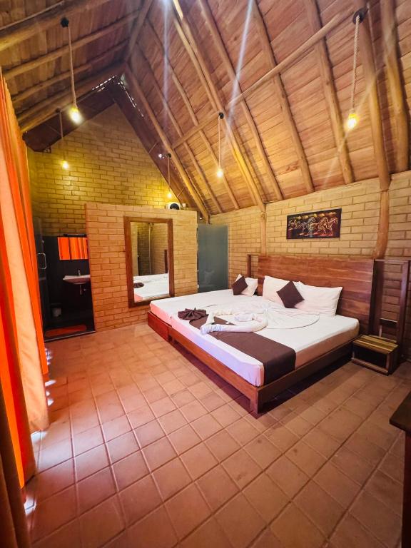 a bedroom with a large bed in a room at Deduru Oya Cinnamon Gardens in Barandara