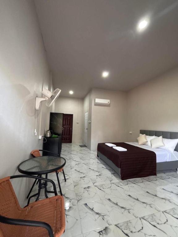 a bedroom with a bed and a table and a chair at MWELL House in Ban Klang