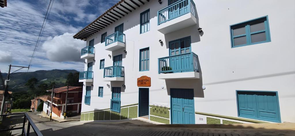 a white building with blue doors and windows at Portón del Río Jericó in Jericó