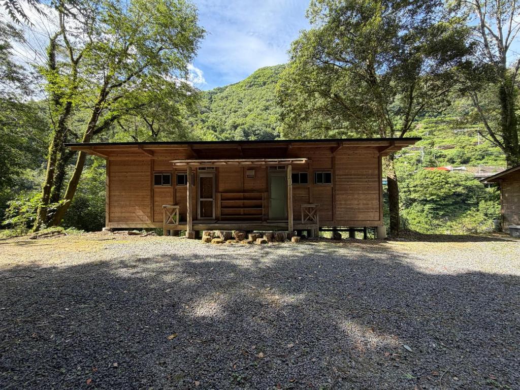 a small wooden cabin with a mountain in the background at YAMAYA BASE 1 in Ōkawamochi