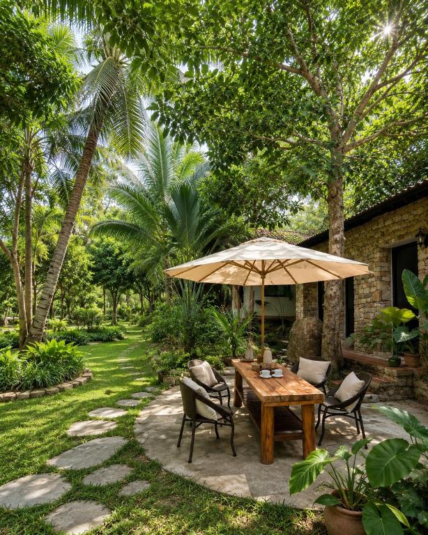 a patio with a table and chairs and an umbrella at MK Hill resort Phu Quoc in Phú Quốc