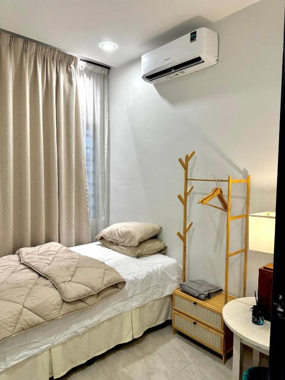 a bedroom with a bed and a air conditioner on the wall at Ujang Guest House 2 in Batu Kikir