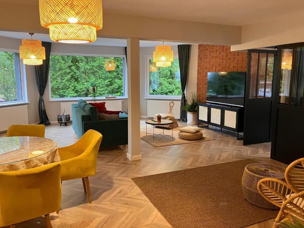 a living room with a couch and a table at Comfortable Jacuzzi Apartment for 8 in Stezyca in Stężyca